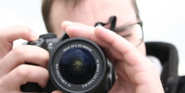 Image of a photographer pointing the camera at the viewer